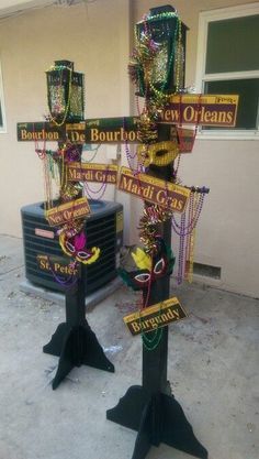 two street signs are decorated with mardi gras decorations