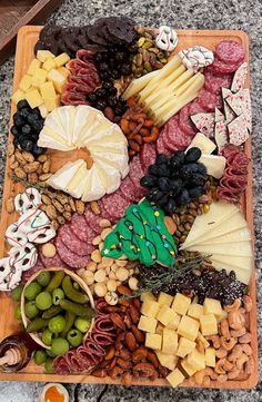 an assortment of cheeses, meats and olives on a platter