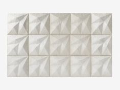 a white tile wall with many different shapes and sizes on it's sides, including one