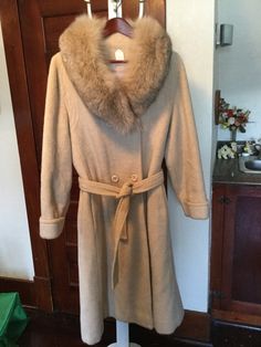 This is just a beautiful women's double breasted coat with a classic shape in a lovely soft beige colour. The coat, made by Sterling Stall, is made of a wool blend with a faux fur collar. It has a belt, cuffs on the sleeves,  two outer pockets and stitching detail around the yoke. It is fully lined. The measurements, taken with the coat lying flat, are: shoulder to shoulder, 17 inches; armpit to armpit, 19 1/2 inches; sleeves, 24 inches; overall length, 46 inches; sweep, 44 inches. About women's size small to small medium. In excellent condition. Beige Fitted Shawl Collar Outerwear, Fitted Beige Outerwear With Shawl Collar, Winter Wool Fur Coat In Beige, Beige Wool Fur Coat For Winter, Winter Beige Wool Fur Coat, Elegant Beige Wool Coat For Cold Weather, Classic Beige Pea Coat For Cold Weather, Cream Pea Coat For Winter, Beige Winter Pea Coat For Formal Occasions