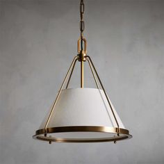 a light fixture with a white shade hanging from it's center point on a gray wall