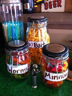 three jars filled with different types of candy sitting on top of a green countertop