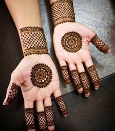 two hands with henna tattoos on them