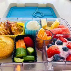 a plastic container filled with lots of different types of food next to a muffin