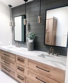 a bathroom with two sinks and mirrors on the wall