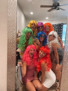 a group of women dressed in wigs taking a selfie