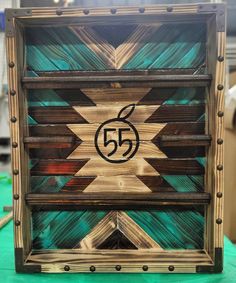 a wooden frame with the number 55 on it and an arrow in the center is made out of wood strips