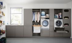 a washer and dryer in a room with shelves on the wall next to each other