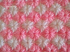 a crocheted pink and white blanket is shown