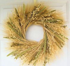 a wreath made out of dried grass hanging on a door