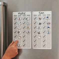 someone is pointing to two magnets on the side of a refrigerator