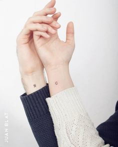 a woman's hand with a small tattoo on her wrist and the word love