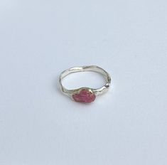 This exquisite ring is a unique creation, handcrafted with care and attention to detail. Made from sterling silver and adorned with a natural untreated pink sapphire, this one-of-a-kind piece is a true gem. The soft hue of the pink sapphire exudes elegance and charm, making it a perfect accessory for any occasion. The properties of the pink sapphire include promoting love, compassion, and emotional balance. Each facet of this ring reflects craftsmanship and the beauty of natural elements, ensuring that it stands out as a distinctive and timeless adornment. Embrace the allure of this exclusive handmade ring, designed to captivate and enhance your individual style. Size is 17.3mm Pink Ring With Bezel Setting, Silver Jewelry With Pink Sapphire Gemstone, Pink Bezel Set Ring Jewelry, Silver Ring With Pink Sapphire, Pink Bezel Set Ring, Pink Tourmaline Sapphire Ring Gift, Pink Sapphire Gemstone Stackable Rings, Silver Round Ring With Pink Sapphire, Pink Sapphire Sterling Silver Ring