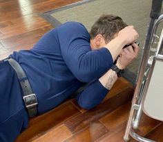 a man laying on the ground with his head in his hands