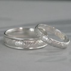 two wedding rings with engraved designs on them