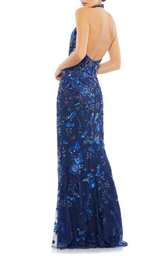 A glittering garden cascades down this flattering sheath gown styled with an alluring halter neckline and daring open back. 63" length Halter neck Sleeveless Lined 100% polyester Dry clean Imported Halter Neck Prom Dress, Halter Dress Formal, Green Evening Gowns, High Neck Prom Dress, Matric Dance, Blue Halter Dress, Sheath Gown, Sequin Formal Dress, Mac Duggal Dresses