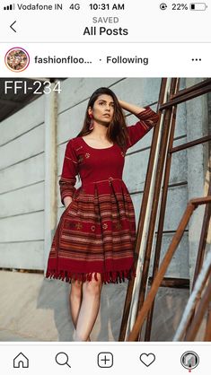 a woman in a red dress standing next to some stairs