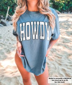 This stylish Howdy Shirt is the perfect mix of vintage southern style and modern comfort. With a classic cowgirl graphic and oversized fit, it's sure to make a statement in any Texas wardrobe. ⭐️ * I T E M * I N F O* ✦ Comfort Colors Unisex Shirt ✦ 100% Ring-Spun Cotton ✦ Printed using Direct To Garment style- Inks are printed directly into the fabric. ✦ Different sizing may effect placement of final design. ✦ Colors may differ slightly due to different user monitor and screen settings. 📏 * S I Oversized Western Tops For Summer, Oversized Western Style Tops For Summer, Western Style Oversized Tops For Summer, Oversized Summer Tops For Rodeo, Oversized Tops For Summer Rodeo, Western Style Summer Tops With Letter Print, Camp Outfits, Howdy Shirt, Classic Cowgirl