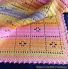 three crocheted afghans sitting next to each other on top of a blue blanket