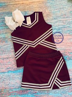 Cute girls cheerleading uniform! Great for spirit days, pep rallies and sporting events! This can be customized for your team and is available in multiple color selections. Set included skirt and shell & mascot embroidered across the front (bow not included). Maroon/white is a new color for us this year so we've included a sample of the maroon/gold to show the style of embroidery that is included. You will receive the maroon/white version (no gold). UNIFORM COLORS: Maroon with white & silver tri Red And Gold Cheer Uniform, Maroon And Gold Cheer Uniform, Maroon Cheer Uniforms, School Spirit Stretch Tops For Cheerleading, Fitted Tops For Cheerleading With School Spirit, Fitted Red Tops For Cheerleading, Red Fitted Tops For Cheerleading, White Cotton Cheerleading Sets, White Fitted Tops For Cheerleading