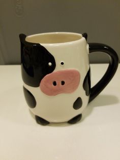 a black and white cow mug sitting on top of a table