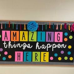 a sign that says amazing things happen here on the wall in front of a door