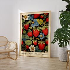 a strawberry print on a wall next to a chair and potted plant in a room