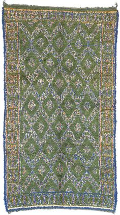 an old green rug with blue and yellow trimmings on the bottom, in front of a white background