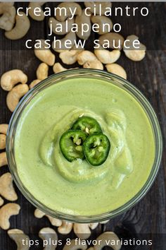 a bowl filled with cashew sauce and two jalapenos