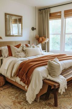 a bedroom with a large bed and pillows on top of the bedspread in front of two windows