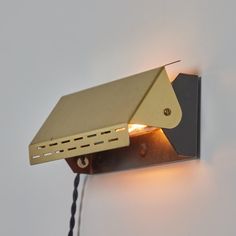 a light that is on the side of a wall with a cord attached to it