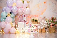 a cake on a table in front of balloons