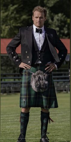 a man in a kilt standing with his hands on his hips