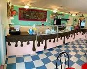 an ice cream shop with blue and white checkered flooring, red chairs and tables