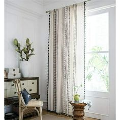 a living room with white walls and curtains