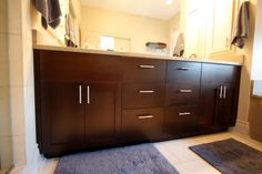 a bathroom with two rugs on the floor and a large cabinet in the middle