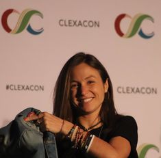 a woman is holding up a jacket and smiling