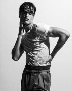 black and white photograph of a young man holding his hand to his head while talking on the phone