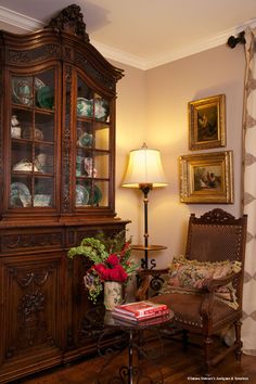 an old china cabinet in the corner of a living room