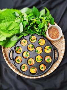 small appetizers are placed on a plate next to some herbs and seasoning