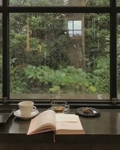 an open book sitting on top of a counter next to a window