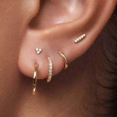 a woman's ear with three different types of piercings