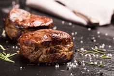 two pieces of meat sitting on top of a table