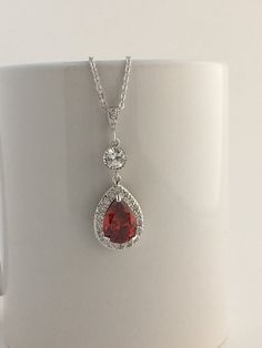 I've created this gorgeous luxury red ruby cubic zirconia bridal tear drop earrings in rhodium plated brass setting. Earrings feature a large teardrop with pear cut red ruby cubic zirconia center surrounded by tiny round zirconia crystals. Teardrop dangles from a round cubic zirconia connector and zirconia detailed ear wire. Total length of the earrings is 5 cms. For matching necklace click: https://www.etsy.com/listing/481708432/red-ruby-cubic-zirconia-bridal-necklace?ref=shop_home_active_20 ht Red Drop Jewelry For Anniversary, Elegant Red Drop Jewelry, Glamorous Red Cubic Zirconia Jewelry, Red Cubic Zirconia Glamorous Jewelry, Elegant Red Teardrop Bridal Earrings, Red Pear-shaped Wedding Earrings, Red Pear-shaped Jewelry For Party, Pear-shaped Ruby Jewelry For Wedding, Ruby Drop Jewelry For Wedding