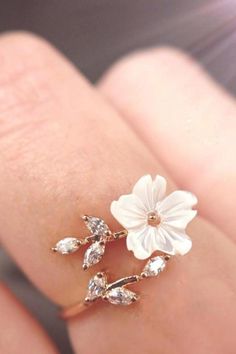 A woman wearing a flower ring. Delicate Rose Gold Flower Ring For Gift, Dainty White Cubic Zirconia Rings, Rose Gold Flower-shaped Cubic Zirconia Rings, Rose Gold Flower-shaped Rings With Cubic Zirconia, White Dainty Cubic Zirconia Rings, White Cubic Zirconia Dainty Rings, Cubic Zirconia Flower Promise Ring, Dainty 3d Flower Jewelry, Delicate Rose Gold Flower Ring