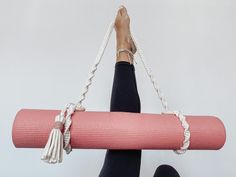 a woman is doing yoga with a pink mat and tassels on her feet