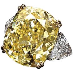 This exquisite ring showcases a stunning 5.09 Carat Cushion Cut Diamond with a GIA Certified Fancy Yellow color grade. The diamond, with an impressive VVS2 Clarity, exhibits exceptional brilliance thanks to its Excellent Polish and Symmetry. The Faint Fluorescence subtly enhances its natural beauty. The ring's unique design features an 18K white gold band, providing a strong and elegant foundation, while the yellow gold prongs beautifully highlight the vibrant yellow hue of the central stone. Fl Graff Yellow Diamond Ring, Fancy Yellow Diamond Ring, Radiant Diamond Rings, Cushion Diamond Ring, Yellow Cushion, Yellow Diamonds Engagement, Cushion Cut Diamond Ring, Yellow Diamond Engagement Ring, Art Investment