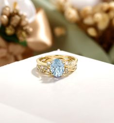 a close up of a ring with a blue stone in it on a white surface