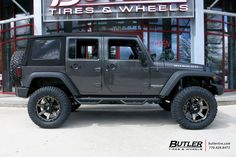 a gray jeep parked in front of a tire store