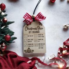 a christmas tree ornament hanging from a red and white ribbon next to ornaments